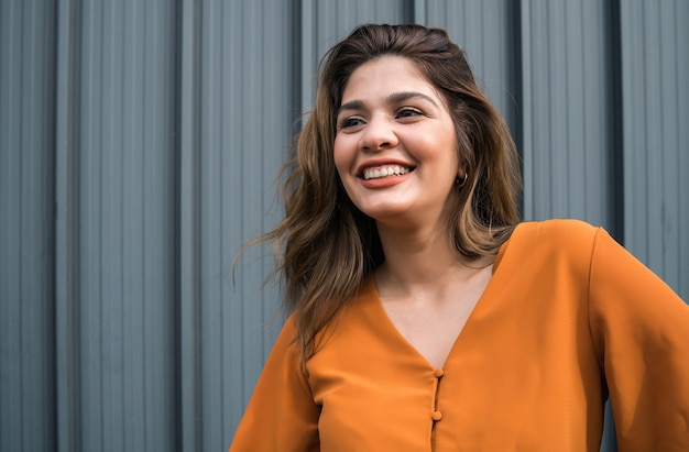 Close-up van de jonge vrouw die lacht terwijl hij buiten op straat staat