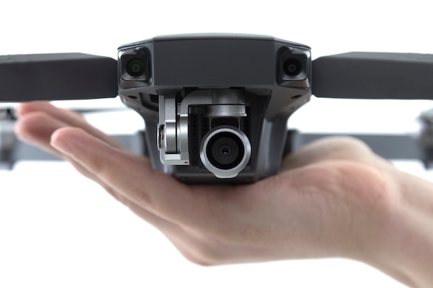 Foto close - up van de quadcopter camera op de palm van een man op een wit