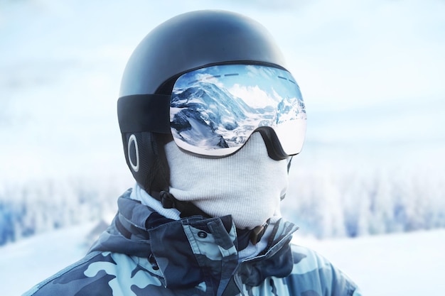 Close-up van de skibril van een man met de weerspiegeling van besneeuwde bergen