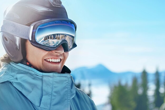 Close-up van de skibril van een man met de weerspiegeling van besneeuwde bergen