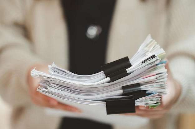 Close-up van de stapeling van vrouwelijke kantoormedewerkers en zakenvrouwen met een stapel papierwerk