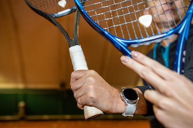 Close-up van de sterke hand van een man die een racket vasthoudt