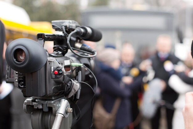 Foto close-up van de televisiecamera met mensen op de achtergrond