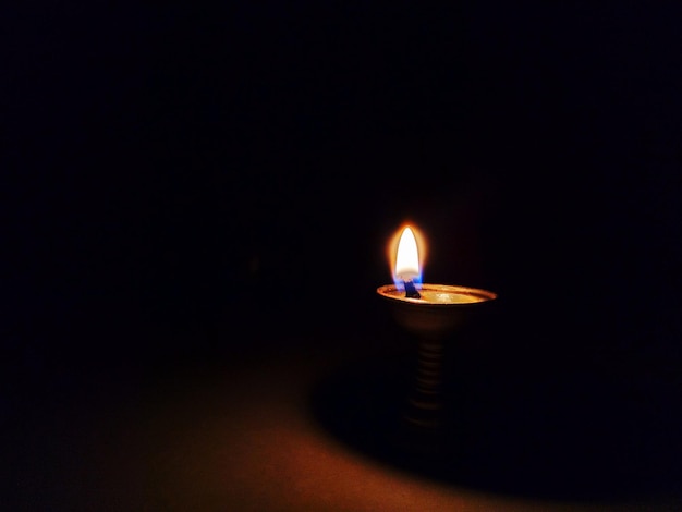 Close-up van de verlichte diya tegen een zwarte achtergrond