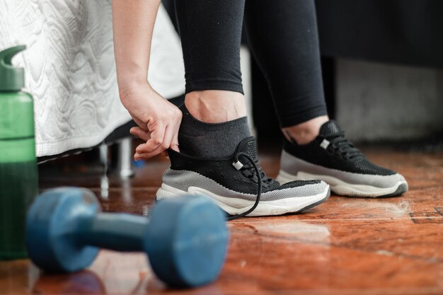 Close-up van de voeten van een meisje dat haar hardloopschoenen aantrekt om te gaan hardlopen