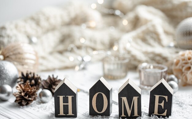 Close-up van decoratief houten woord huis op onscherpe achtergrond met details van kerstvakantie decor.