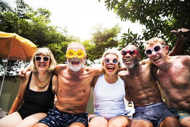 Close-up van diverse hogere volwassenen die door de pool zitten die van de zomer samen genieten