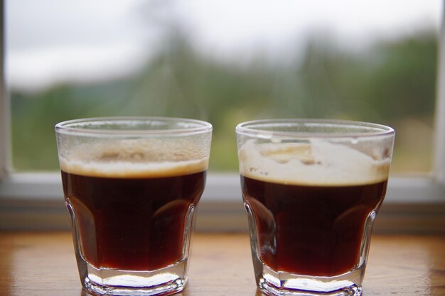 Foto close-up van drank in glazen op de vensterbank