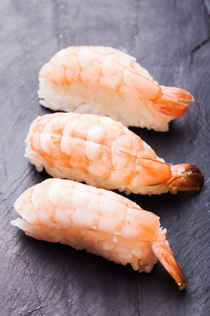 Close-up van Ebi-sushi met garnalen op een zwarte leiachtergrond