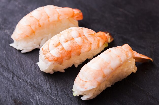 Close-up van Ebi-sushi met garnalen op een zwarte leiachtergrond