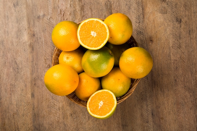 Close-up van een aantal sinaasappelen in een mand op een houten oppervlak. Vers fruit.