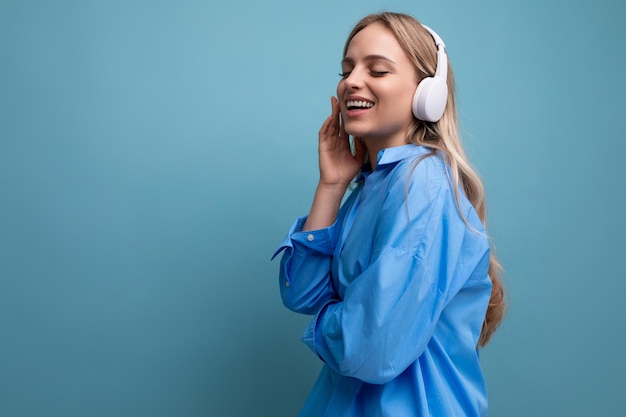 Close-up van een aantrekkelijk meisje in draadloze grote koptelefoons die weet hoe ze moet ontspannen met muziek op een