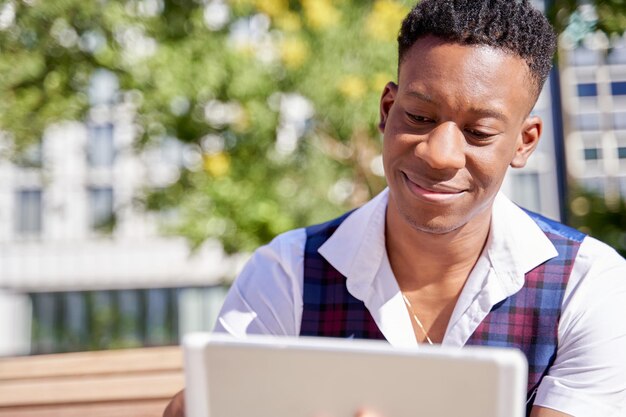 Close-up van een Afro-Amerikaanse jongere die zijn tablet-pc gebruikt