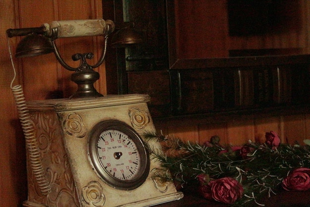 Foto close-up van een antieke telefoon en bloemen op tafel