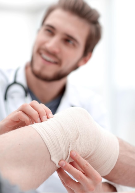 Close-up van een arts die het gewonde been van de patiënt onderzoekt