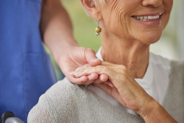 Close-up van een arts en patiënt hand in hand Zoom op arts die een patiënt ondersteuning biedt tijdens herstel Een liefhebbende arts die de hand van haar patiënt vasthoudt en vriendelijkheid toont tijdens een controle