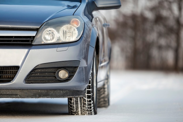 Close up van een autoband geparkeerd op besneeuwde weg op winterdag. Transport- en veiligheidsconcept.