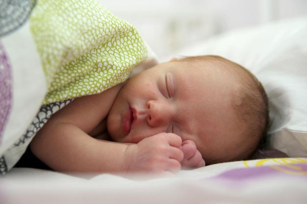 Close-up van een baby die op het bed slaapt