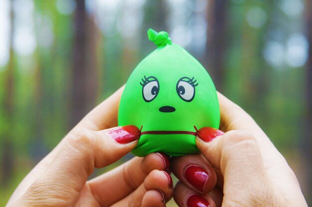 Foto close-up van een ballon in de hand met een antropomorfe gezicht