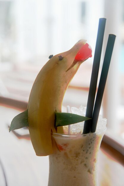 Close-up van een banaan in een drinkglas op tafel