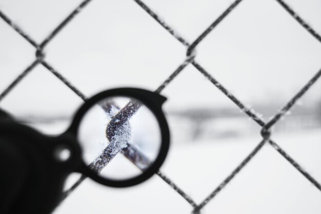 Foto close-up van een bevroren kettinghek gezien vanuit een vergrootglas