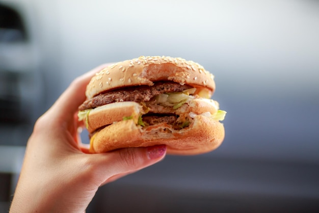 Close-up van een bijgesneden hamburger met de hand