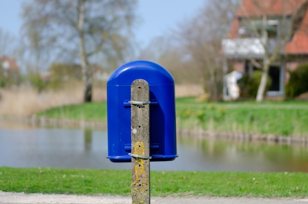 Foto close-up van een blauwe brievenbus op gras in een park