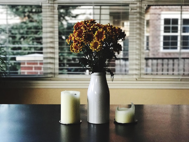 Foto close-up van een bloemenvaas op tafel tegen het raam