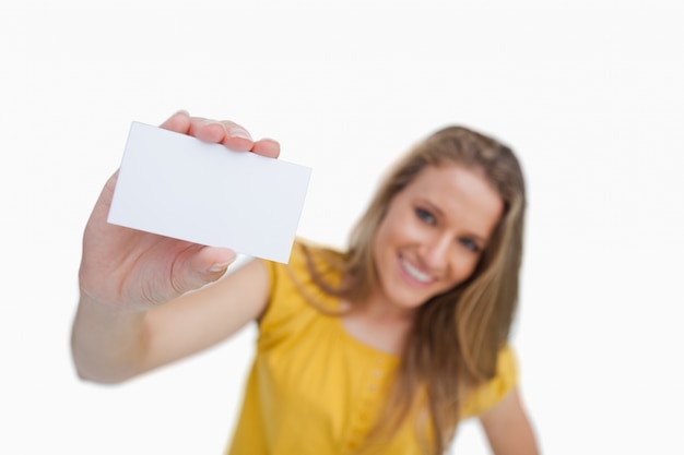 Close-up van een blonde vrouw die een witte kaart toont