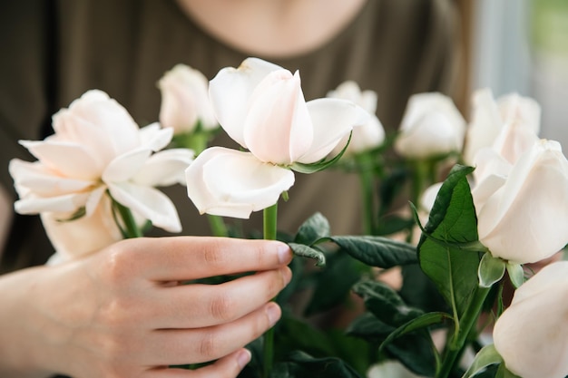 Close-up van een boeket rozen in de handen van een vrouwelijke bloemist