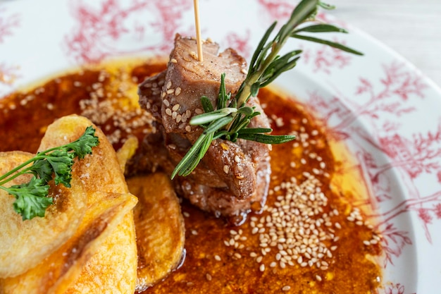 Foto close-up van een bord bonito met teriyaki saus en zelfgemaakte aardappelchips mediterrane keuken