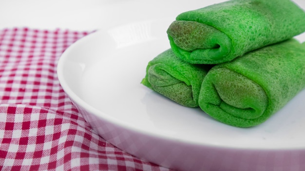 Close-up van een bord met Indonesische Coconut Filled Pandan Pancake Rolls