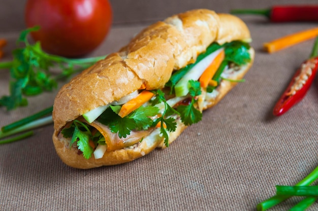 Foto close-up van een boterham met tomaten en chili pepers op tafel