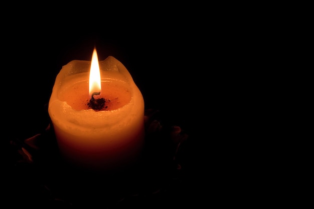 Close-up van een brandende kaars in de donkere kamer
