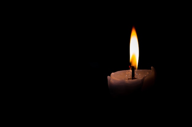 Close-up van een brandende kaars in de donkere kamer