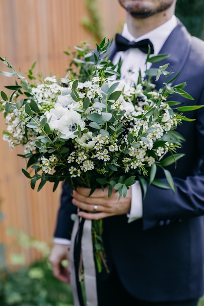 close up van een bruidegom die bruids boeket