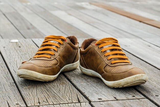 Foto close-up van een bruine schoen op een houten platform