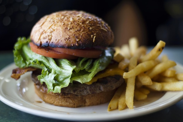 Foto close-up van een burger met friet geserveerd op een bord