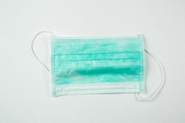 Close-up van een chirurgisch masker tegen een witte achtergrond