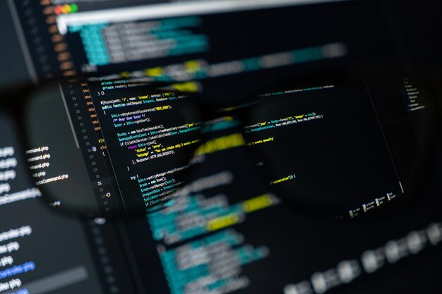 Close-up van een computerscherm met kleurrijke code door middel van een bril softwareontwikkeling programmering codering en technologie