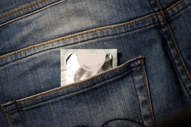 Close-up van een condoompakket in de zak van een spijkerbroek