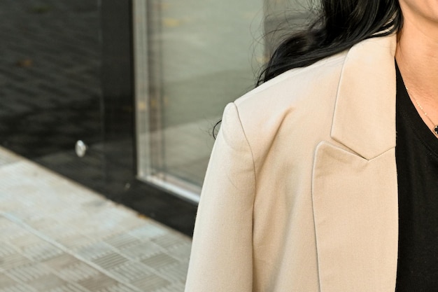 Close-up van een dame in een stijlvol beige jasje Stijlvol jasje Details Ruimte kopiëren