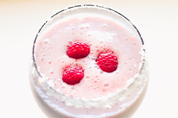 Foto close-up van een dessert in glas tegen een witte achtergrond