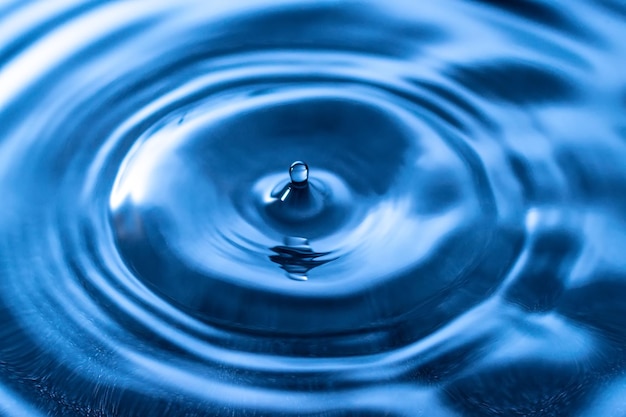 Close-up van een druppel die op water valt