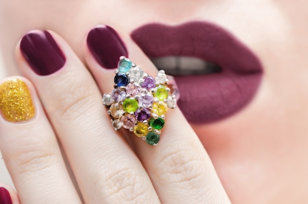 Close-up van een elegante zilveren ring met kleur edelstenen.