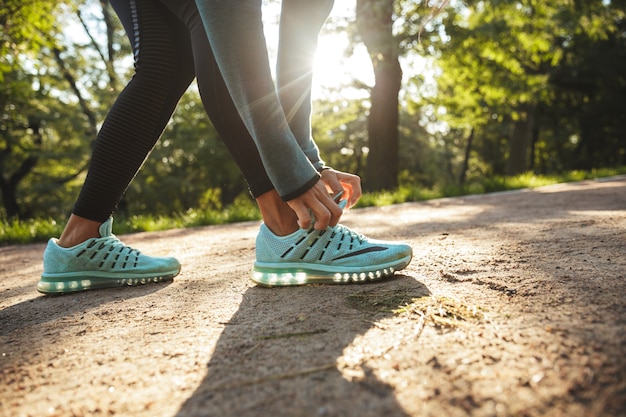 Close up van een fitness vrouw haar schoenveter buitenshuis koppelverkoop