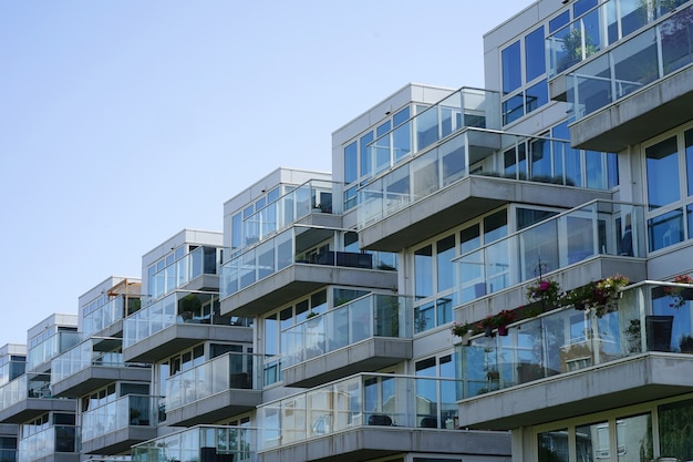 Close-up van een flatgebouw met balkons van het dorp. achtergrond van ramen en balkons van een glazen gebouw met meerdere verdiepingen.