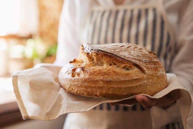 Close-up van een gastvrouw die traditioneel Oekraïens brood vasthoudt dat net uit de oven is gebakken