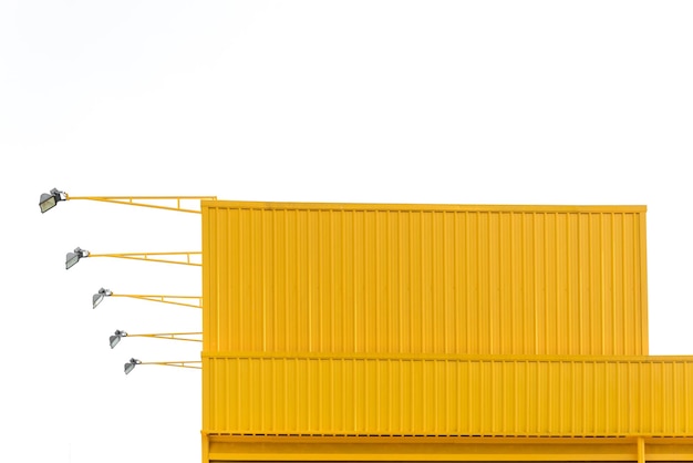Close-up van een gele gebouwde structuur met verlichtingsapparatuur tegen een heldere lucht