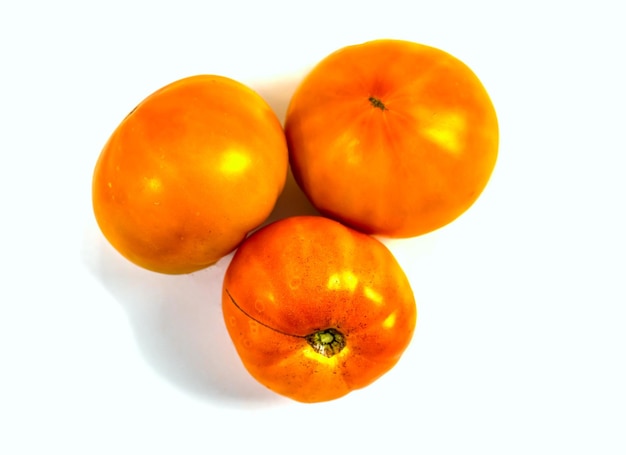 Close-up van een gele oranje tomat geïsoleerd op een witte achtergrond